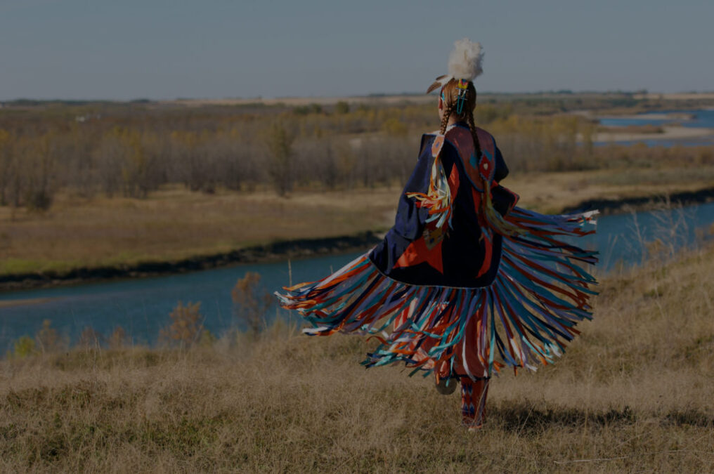 Femme autotochtone dansant sur la prairie